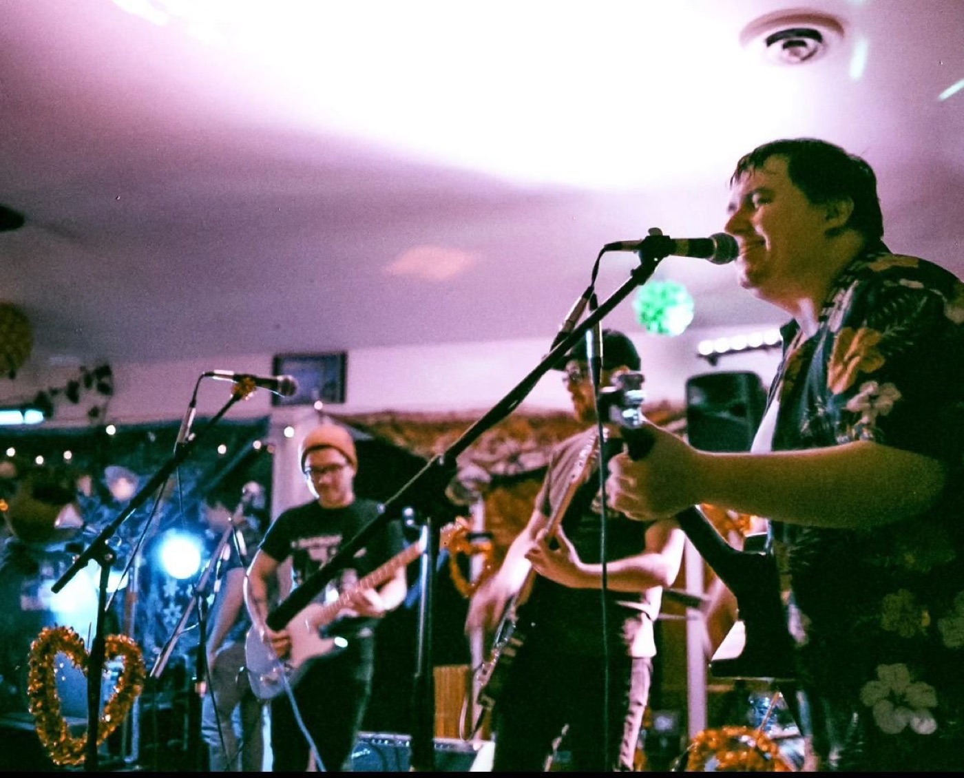 A live band on stage under purple light